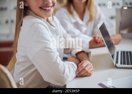 Bella giovane signora passare il tempo alla scrivania dentro ufficio Foto Stock