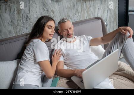 Uomo e donna che guardano sullo schermo del notebook Foto Stock