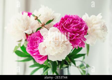 Bouquet di belle peonie in giardino. Peonie rosa e bianche in una caraffa di stagno. Messa a fuoco morbida - immagine Foto Stock