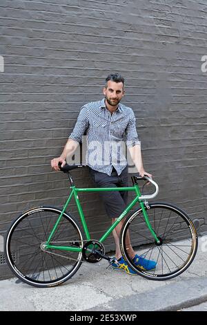 Uomo in piedi di fronte a Green Vintage Bicycle Foto Stock
