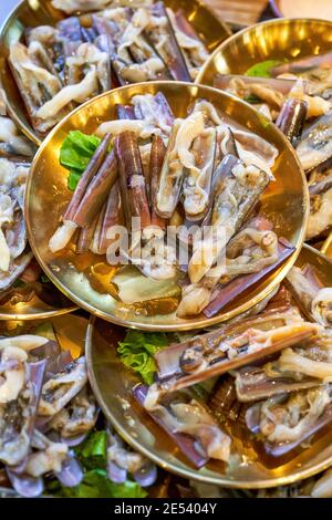 Piatti caldi appena sfornati, lumache fresche, vongole per rasoio Foto Stock