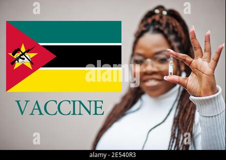 La donna africana mostra il vaccino per la Repubblica del Mozambico. Concetto di vaccinazione dei paesi africani. Foto Stock