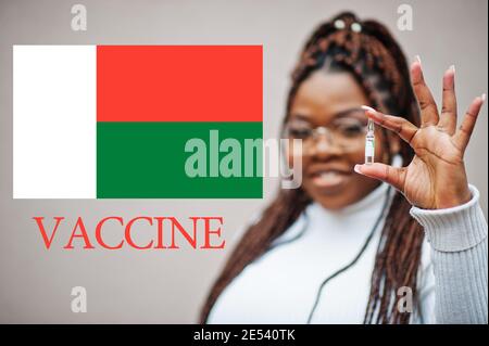 Donna africana mostra vaccino per la Repubblica del Madagascar. Concetto di vaccinazione dei paesi africani. Foto Stock