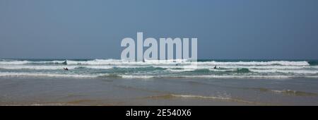 Cornovaglia persone che hanno divertimento onde e mare in muta con Surf Porthtowan Cornish costa nord Foto Stock