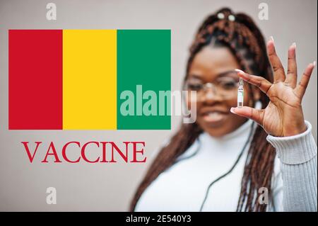 Donna africana mostra vaccino per la Repubblica di Guinea. Concetto di vaccinazione dei paesi africani. Foto Stock