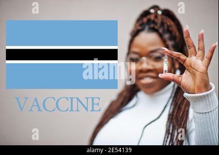 Donna africana mostra vaccino per la Repubblica del Botswana. Concetto di vaccinazione dei paesi africani. Foto Stock