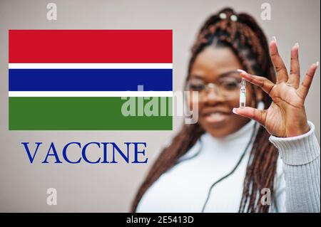 Donna africana mostra vaccino per la Repubblica della Gambia. Concetto di vaccinazione dei paesi africani. Foto Stock
