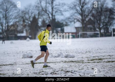 Northampton, Regno Unito, Meteo, 26 gennaio 2021. La gente ottiene l'esercitazione quotidiana che fa jogging e che cammina nella neve che sta posando in Abington Park. Credit: Keith J Smith./Alamy Live News Foto Stock