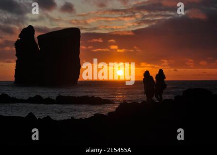 Silhouette di due persone, durante il tramonto, a Mosteiros, isola di Sao Miguel, Azzorre. Foto Stock