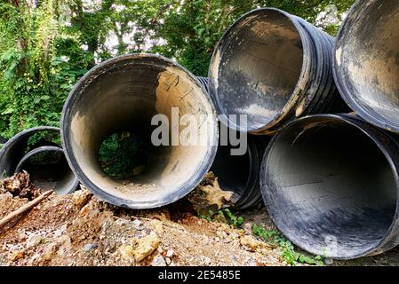 Pali di grandi tubi in pvc lungo il lato della strada, utilizzati in un progetto di riabilitazione delle acque reflue sull'isola di Boracay, Filippine, Asia Foto Stock