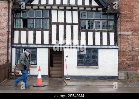 Bewdley, Worcestershire, Regno Unito. 26 gennaio 2021. Le acque alluvionali si defondono dopo che la città di Bewdley, Worcestershire, è stata parzialmente allagata dal fiume Severn. Un uomo cammina attraverso un edificio storico che aveva cinque piedi di acqua alluvionata quando le difese del fiume sono fallite. Credit: Peter Lopeman/Alamy Live News Foto Stock