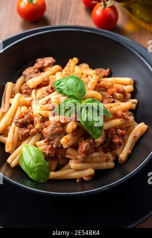 Piatto di pasta casereccese con deliciosa salsa bolognese, cucina italiana Foto Stock