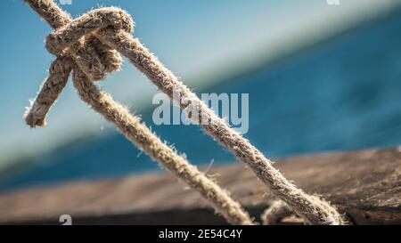 Corde appese su yacht da crociera vicino alla città Foto Stock