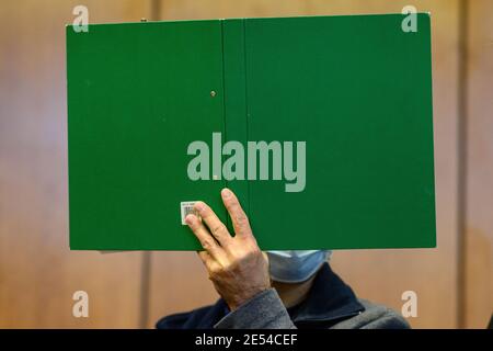 26 gennaio 2021, bassa Sassonia, Göttingen: Il convenuto si trova con una cartella verde al processo authour nel tribunale distrettuale. Si dice che l'imputato abbia sparato la moglie addormentata. Foto: Swen Pförtner/dpa Foto Stock