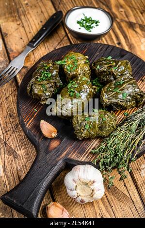 Dolma georgiano tradizionale in foglie d'uva. Sfondo in legno. Vista dall'alto Foto Stock