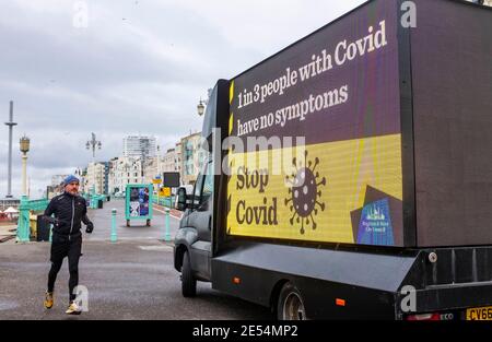 Brighton UK 26 gennaio 2021 - UN grande cellulare 'Stop COVID' Brighton e Hove City Council pubblicità imbarco parcheggiato sul lungomare oggi come le restrizioni di blocco continuano in Inghilterra e nel Regno Unito: Credit Simon Dack / Alamy Live News Foto Stock