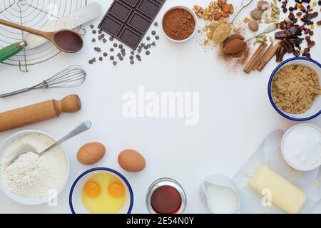 Ingredienti da forno e utensili da cucina su sfondo bianco di legno Foto Stock