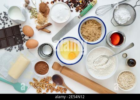 Ingredienti da forno e utensili da cucina su sfondo bianco di legno Foto Stock