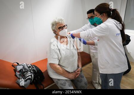 Amburgo, Germania. 26 gennaio 2021. Brigitta Kledke, 83 anni, riceve la sua seconda vaccinazione Corona presso il centro di vaccinazione di Amburgo. Tre settimane dopo la messa in funzione del centro di vaccinazione di Amburgo nelle sale espositive, le prime seconde vaccinazioni sono state somministrate lì martedì. Dal 5 gennaio, le persone con più di 80 anni e i dipendenti dei servizi di assistenza sono chiamati a vaccinarsi presso il centro. Credit: Christian Charisius/dpa/Alamy Live News Foto Stock