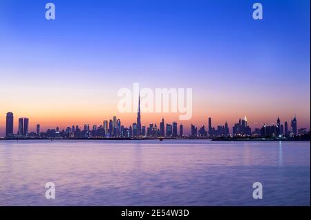 Vista panoramica dello skyline di Dubai con Burj khalifa e. altri raschiatori di cielo catturati al tramonto con il bello Cielo blu al torrente di Dubai Foto Stock