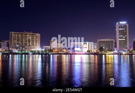 Vista panoramica dei raschiatori illuminati del cielo, degli hotel e degli edifici che mostrano splendidi riflessi in acqua catturata al Seef, Dubai, Emirati Arabi Uniti. Foto Stock