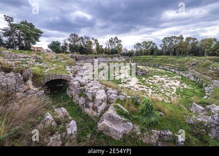 Rovine di arena di anfiteatro romano situato nel Parco Archeologico della Neapolis a Siracusa città, angolo sud-est dell'isola di Sicilia, Italia Foto Stock