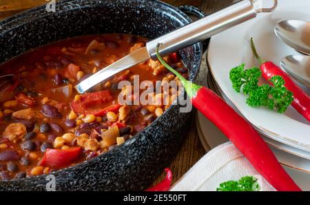 Zuppa di fagioli piccanti in una grande pentola con mestolo dall'alto Foto Stock