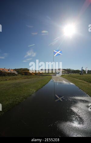 Il campo da golf Trump Turnberry, Ayrshire, Scozia, è uno dei più grandi centri di salvataggio con il Turnberry Hotel sullo sfondo. Bandiera riflessa in un pozze sul percorso Foto Stock