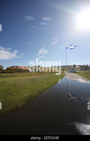 Il campo da golf Trump Turnberry, Ayrshire, Scozia, è uno dei più grandi centri di salvataggio con il Turnberry Hotel sullo sfondo. Bandiera riflessa in un pozze sul percorso Foto Stock