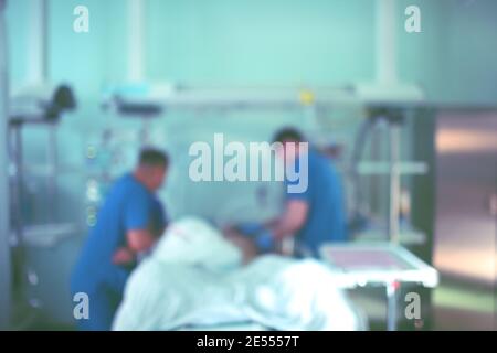 Due persone che lavorano nell'unità di terapia intensiva, background non focalizzato. Foto Stock