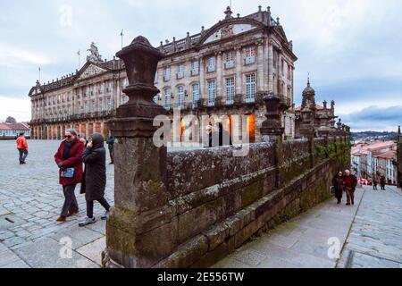 Santiago de Compostela, provincia di Coruña, Galizia, Spagna - 12 febbraio 2020 : la gente cammina oltre il Pazo de Raxoi edificio del municipio neoclassico i Foto Stock