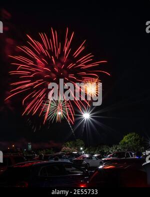 Prattville, Alabama/USA-4 luglio 2020: Spettacolo di fuochi d'artificio vicino alla Torre dell'Orologio con le persone che si godono lo spettacolo dai loro veicoli nel parcheggio circostante Foto Stock