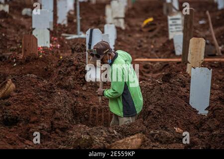 Giacarta, Giacarta, Indonesia. 26 gennaio 2021. Gravi digratori lavorano durante la sepoltura di una vittima di un coronavirus COVID-19 in un cimitero speciale a Giacarta il 26 gennaio 2021, quando l'Indonesia ha superato più di un milione di casi di Covid-19, e l'arcipelago lancia una delle più grandi unità vaccinali del mondo per ridurre il tasso di infezione alle stelle. Credit: Afriadi Hikmal/ZUMA Wire/Alamy Live News Foto Stock