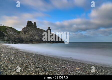 Splendida vista a terra bassa e lunga esposizione delle rovine del castello nero e del mare lungo la linea costiera di Wicklow, South Quay, Corporation Lands, Co. Wicklow Foto Stock