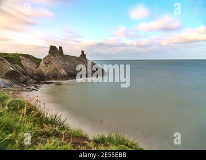 Splendida vista a terra bassa e lunga esposizione delle rovine del castello nero e del mare lungo la linea costiera di Wicklow, South Quay, Corporation Lands, Co. Wicklow Foto Stock