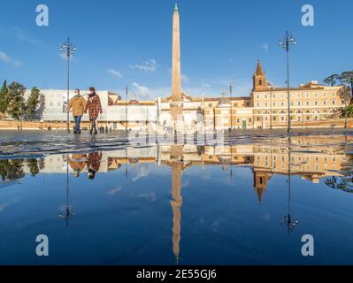 Nel periodo invernale, frequenti docce a pioggia creano piscine in cui il meraviglioso centro storico di Roma si riflette come in uno specchio. Qui si trova Piazza del Popolo Foto Stock