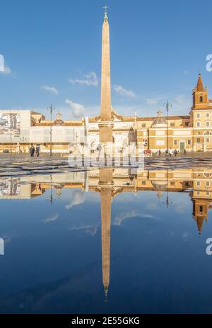 Nel periodo invernale, frequenti docce a pioggia creano piscine in cui il meraviglioso centro storico di Roma si riflette come in uno specchio. Qui si trova Piazza del Popolo Foto Stock