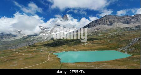 Vista aerea del Monte Cervino (Cervino) e del lago Tramail de Vieille dai campi di Plan Maison, Valle d'Aosta, Italia settentrionale. Foto Stock