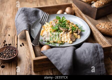 Uova strapazzate nutrienti con funghi, cipolla e prezzemolo per colazione Foto Stock