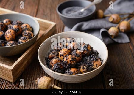 Dolce slovacco pasta di Natale Opekance anche noto come Bobalky OR Pupaky con semi di papavero su rustico sfondo di legno Foto Stock