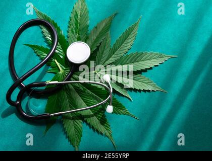 Cannabis medica marijuana olio cbd con stetoscopio su sfondo verde con sfumature. Foto Stock