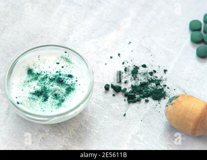 Spirulina e yogurt maschera facciale. Maschera naturale nel recipiente piccolo. Trattamento di bellezza naturale e ricetta termale. Foto Stock