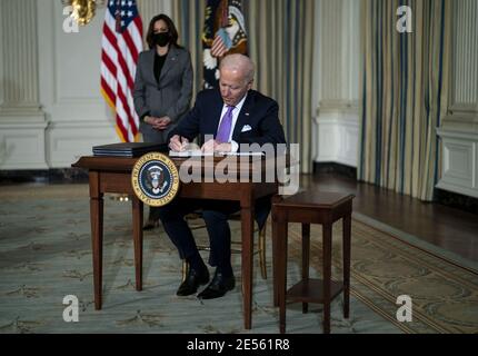 Washington, Stati Uniti. 26 gennaio 2021. Il presidente Joe Biden, a cui ha aderito il vicepresidente Kamal Harris, firma una serie di azioni esecutive per promuovere l'uguaglianza razziale, nella Sala da pranzo di Stato della Casa Bianca, martedì 26 gennaio 2021. Le azioni esecutive mirano a porre rimedio alla discriminazione nelle politiche immobiliari federali, a porre fine all'uso delle prigioni private federali, a riconfermare la sovranità tribale del governo federale e a combattere la discriminazione contro gli americani asiatici che è aumentata durante la pandemia del coronavirus. Foto della piscina di Doug Mills/UPI Credit: UPI/Alamy Live News Foto Stock