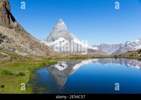Svizzera il Cervino si riflette nel lago di Riffelsee e in mountain bike Foto Stock