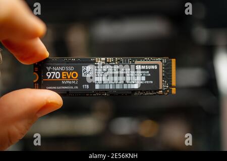 Londra, Regno Unito - Jan 18, 2019: POV personal perspective maschio tiene il nuovo connettore M2 il nuovo disco Samsung NVME V-NAND SSD Samsung 970 con un terabyte di spazio di storage compter di sfondo Foto Stock