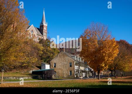 Vecchi edifici commerciali lungo la via Shanendoah con la chiesa di San Pietro sulla collina. Durante l'autunno, in autunno a Harpers Ferry, West Virginia. Foto Stock