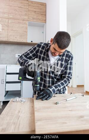 Il falegname finalizzando il montaggio del ripiano della cucina sul pavimento. Foto Stock