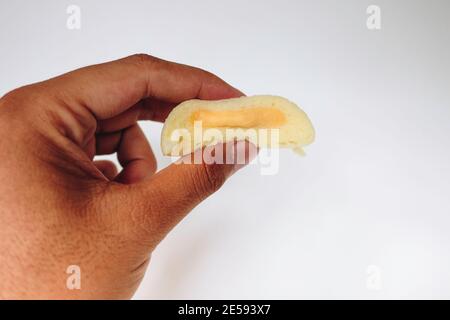 Bakpia Kukus Cake o Bakpia Cake al vapore con gusto formaggio a mano isolato su sfondo bianco. Torta tradizionale Indonesia-cina da yogyakarta Foto Stock