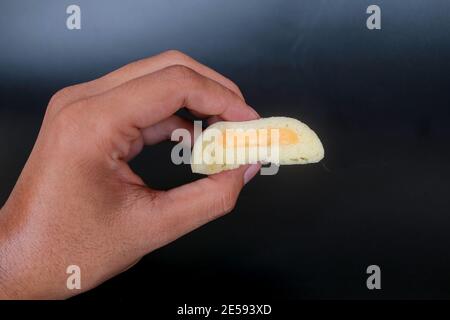 Bakpia Kukus Cake o Bakpia Cake al vapore con gusto formaggio a mano isolato su sfondo bianco. Torta tradizionale Indonesia-cina da yogyakarta Foto Stock