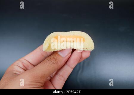 Bakpia Kukus Cake o Bakpia Cake al vapore con gusto formaggio a mano isolato su sfondo bianco. Torta tradizionale Indonesia-cina da yogyakarta Foto Stock